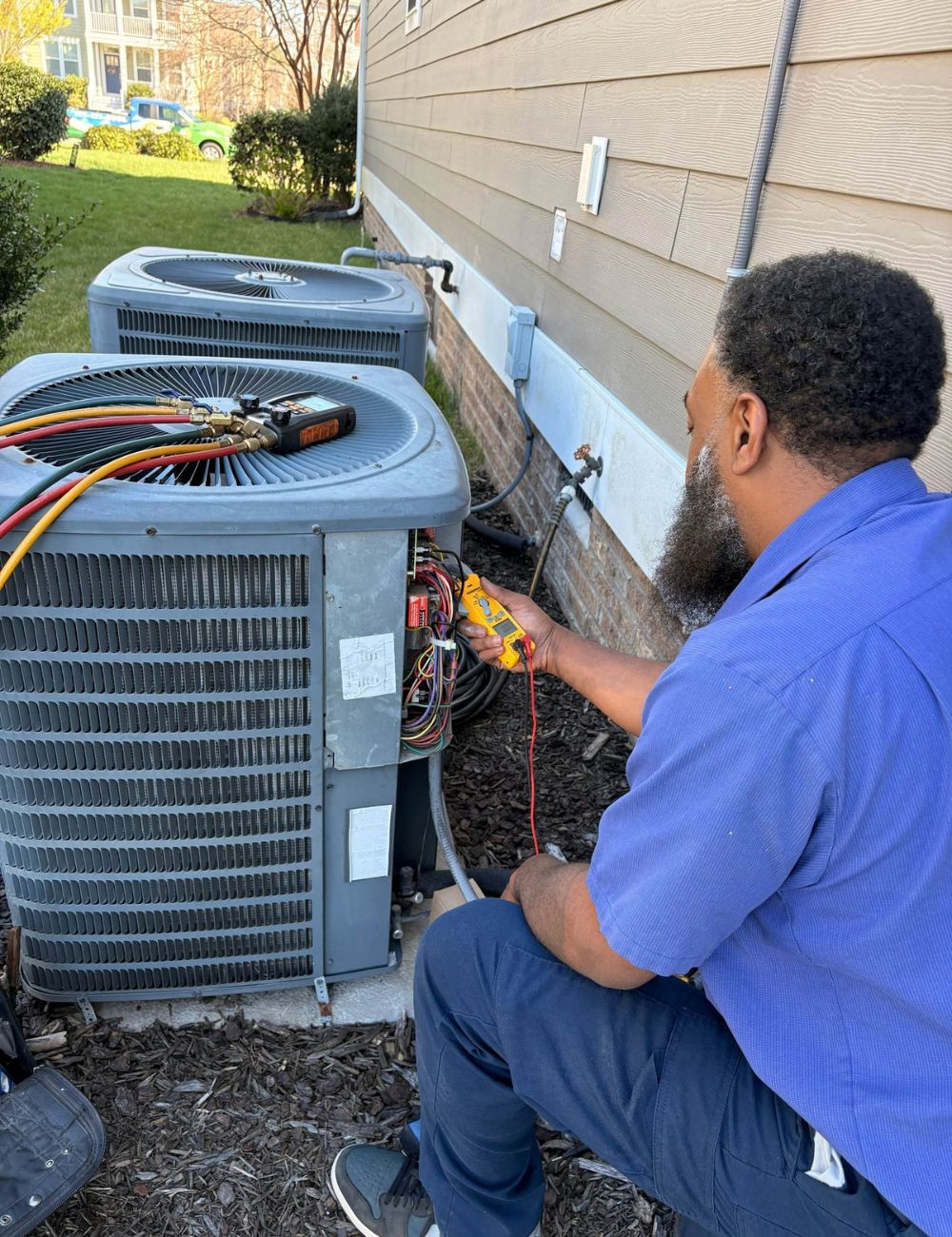 Technician working on the accessible components of a residential air conditioning system